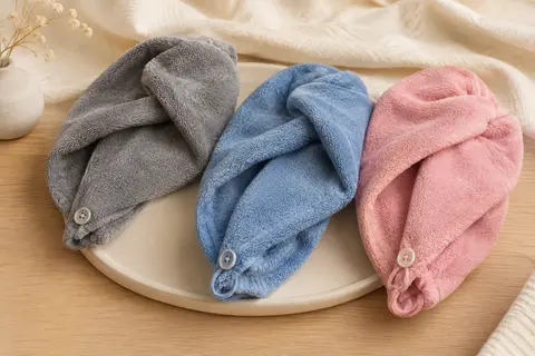 Trois turbans-serviettes en microfibre gris, bleu et rose, avec une fermeture par bouton et boucle