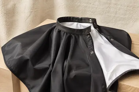 Cape de coiffure noire et blanche en polyester, avec col en silicone et fermeture à boutons-pression