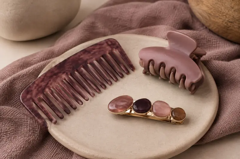 Détail de plusieurs accessoires de coiffure disposés sur des matières douces et mates